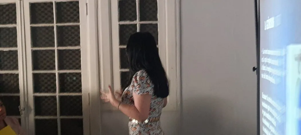 Rayén Milán leyendo de pie frente a la sala