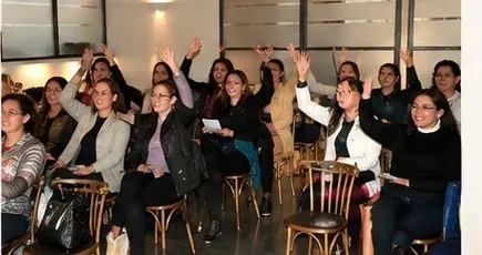 Mujeres levantando la mano durante el taller