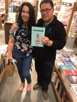 Una lectora con el libro Amarse en la librería