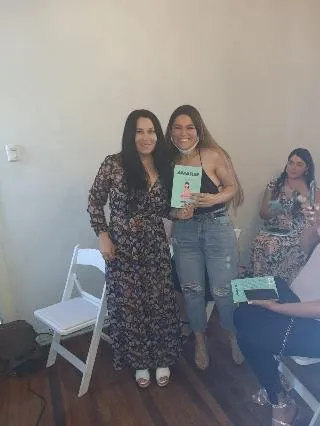 Rayén Milán con una lectora sosteniendo el libro